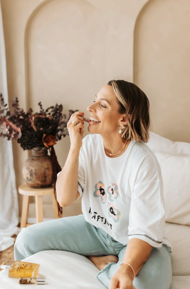 Lady trying on lip balm brand Reve Botanticals